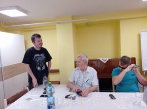 Inštruktor stojí pred skupinou ľudí a rozpráva.